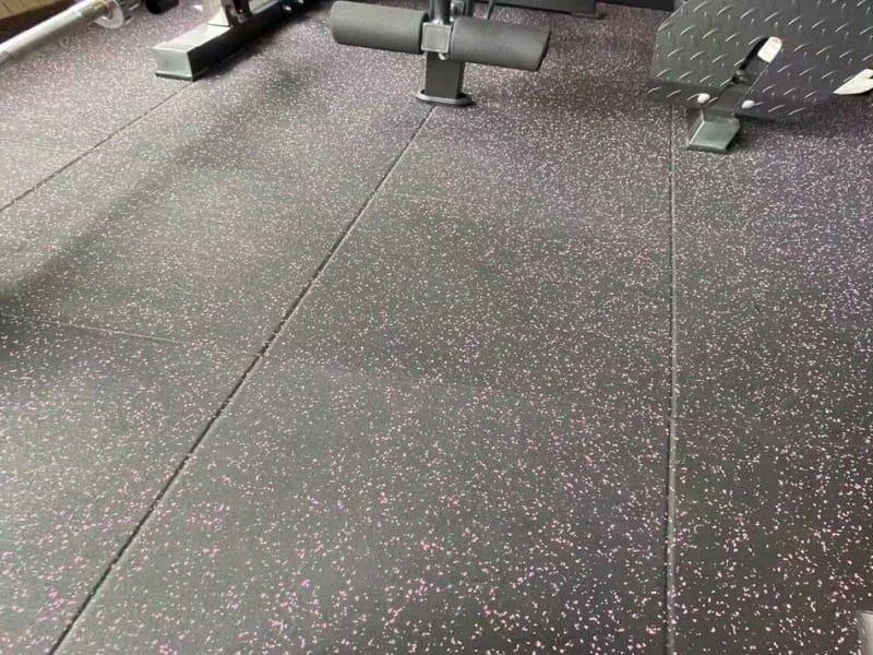 Diagram showing impact force being dissipated by a thick rubber flooring layer over a concrete subfloor.